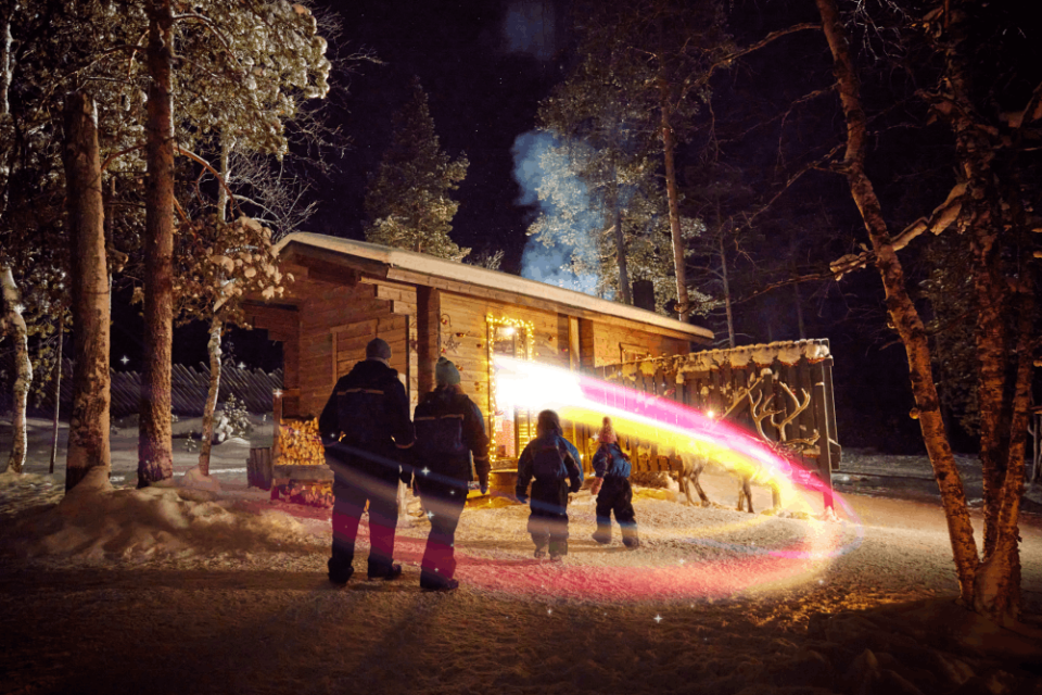 Family at a log cabin in Lapland