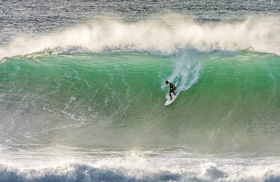 Person surfing in Newquay on a large wave