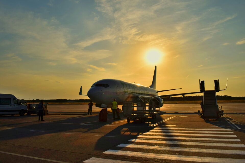 Plane on the tarmac with the sunset behind it.