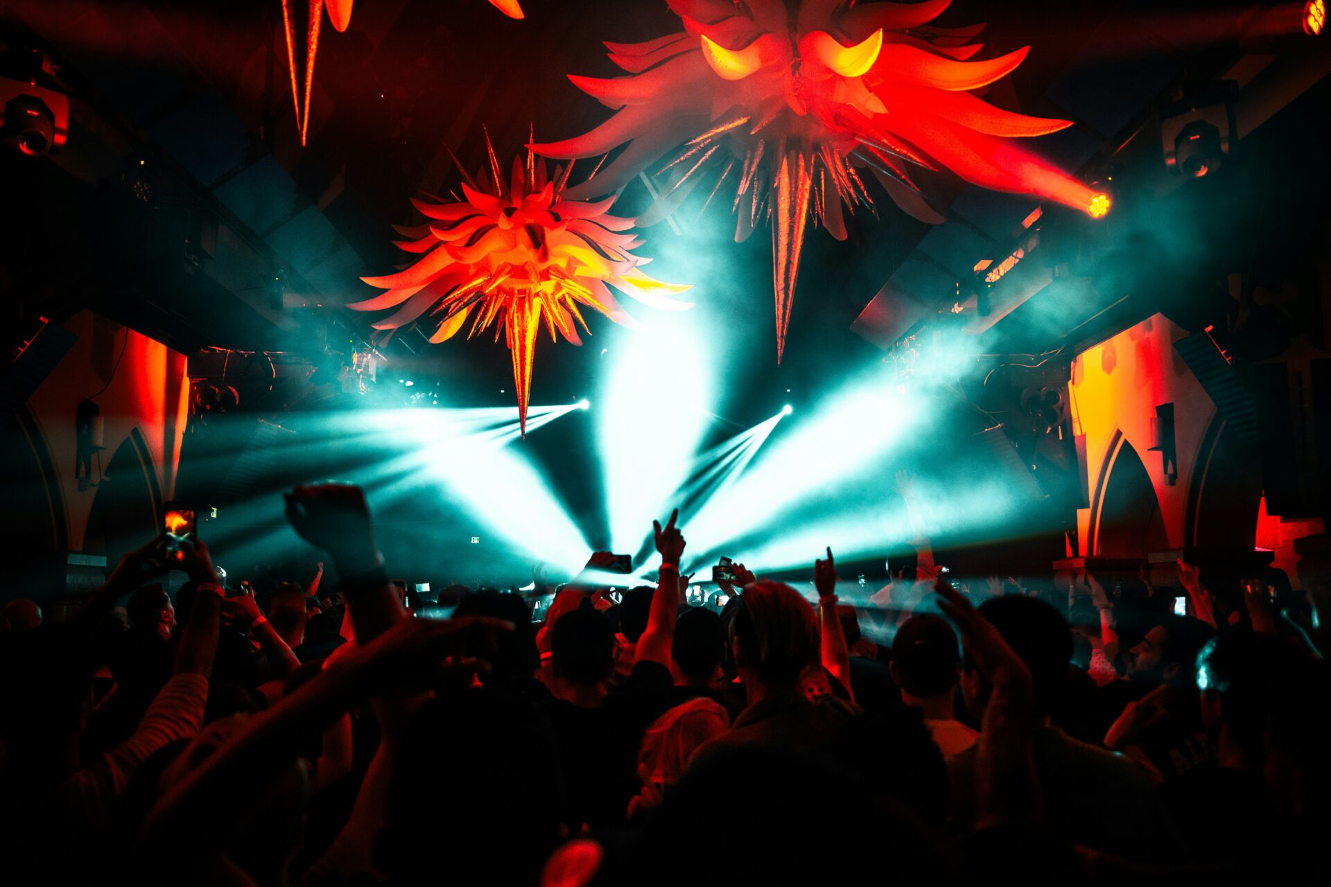 People dancing with strobe lights and hanging decorations.