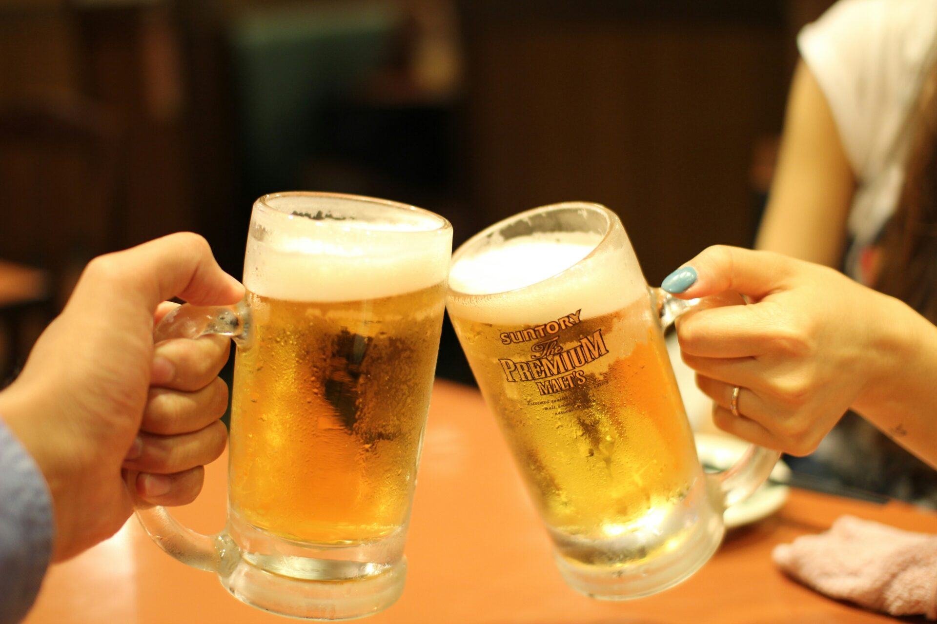 An image of two people holding their beer.