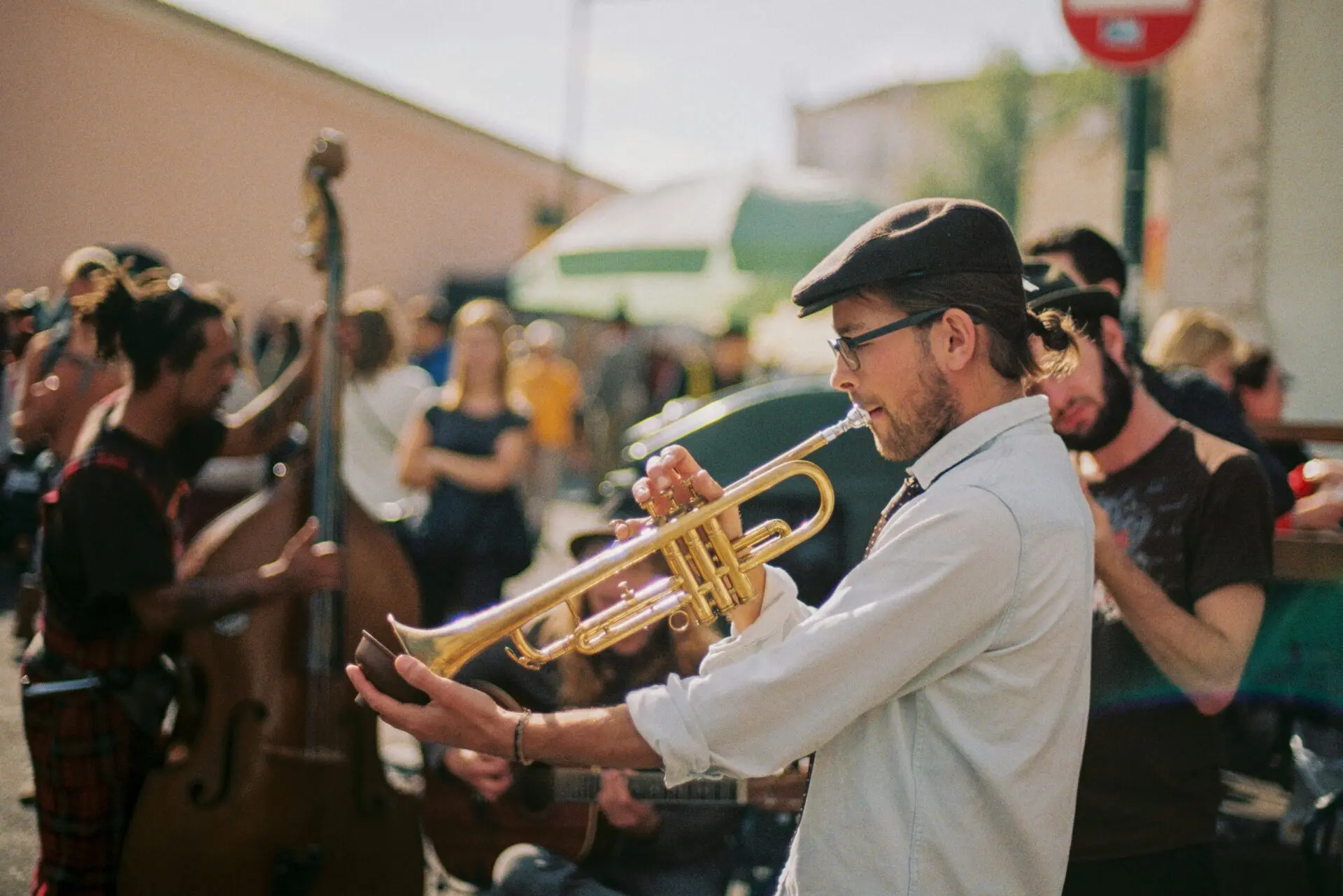 An image of a band playing live music on the street to a group of people.