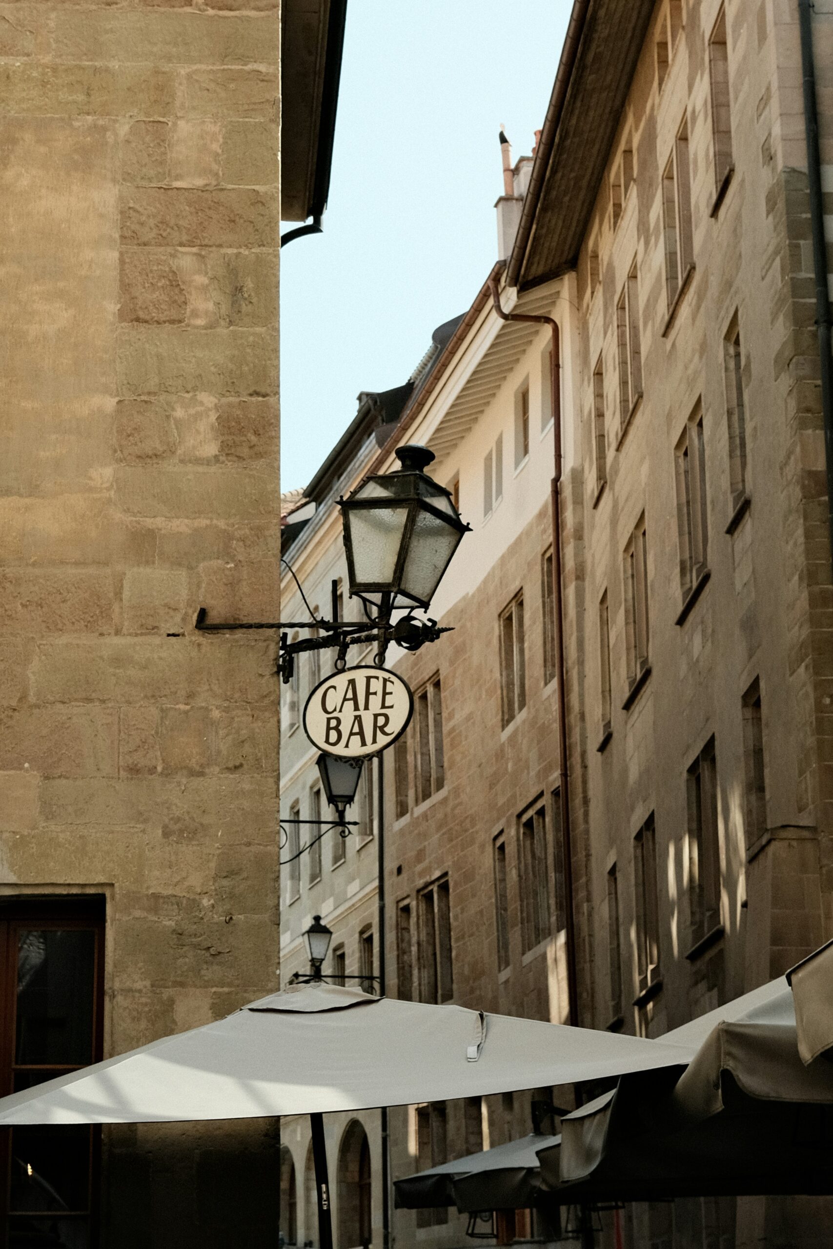 Portrait image of a 'cafe bar' sign in the streets of Geneva.